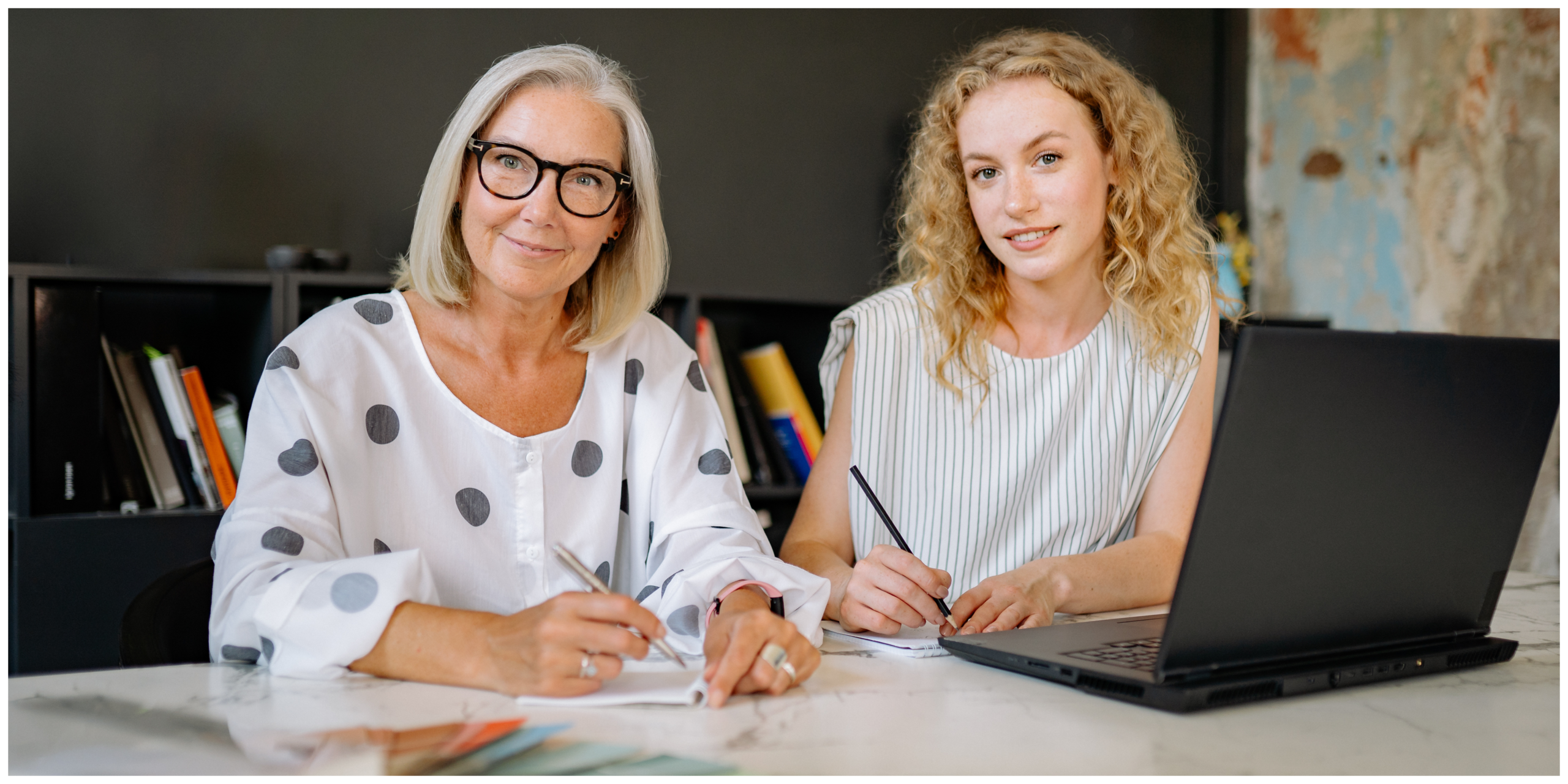 Two nurses working together at a desk with a laptop